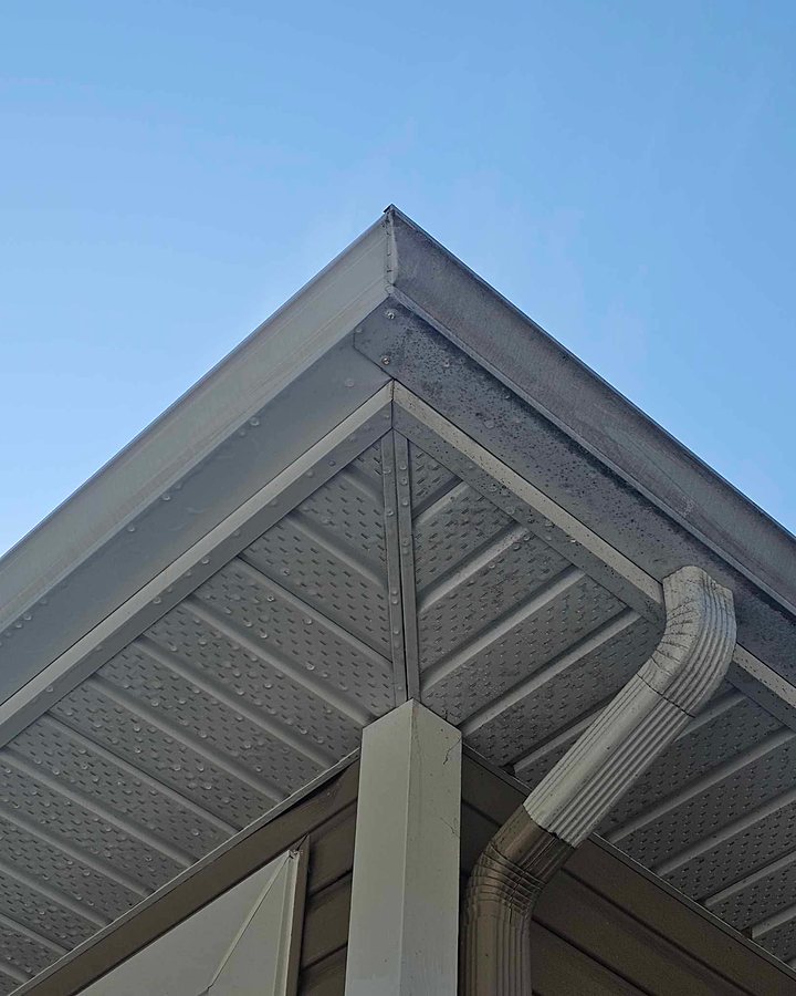 Gouttière et soffites d'aluminium nettoyés par OMAX, sous un ciel bleu
