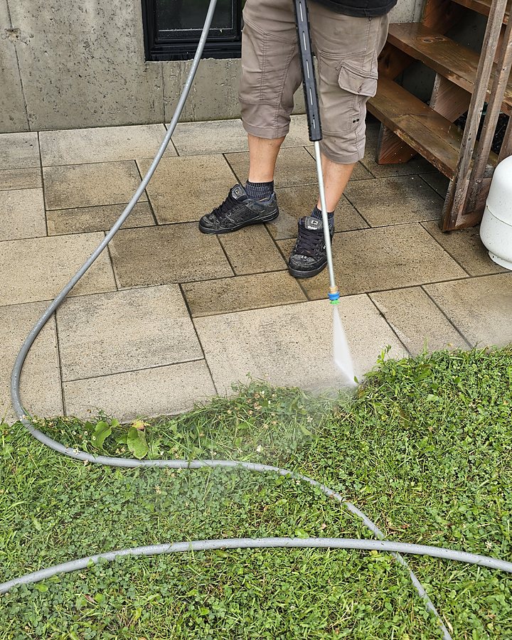 Jet haute pression OMAX nettoyant un pavé uni résidentiel au pied d'un escalier